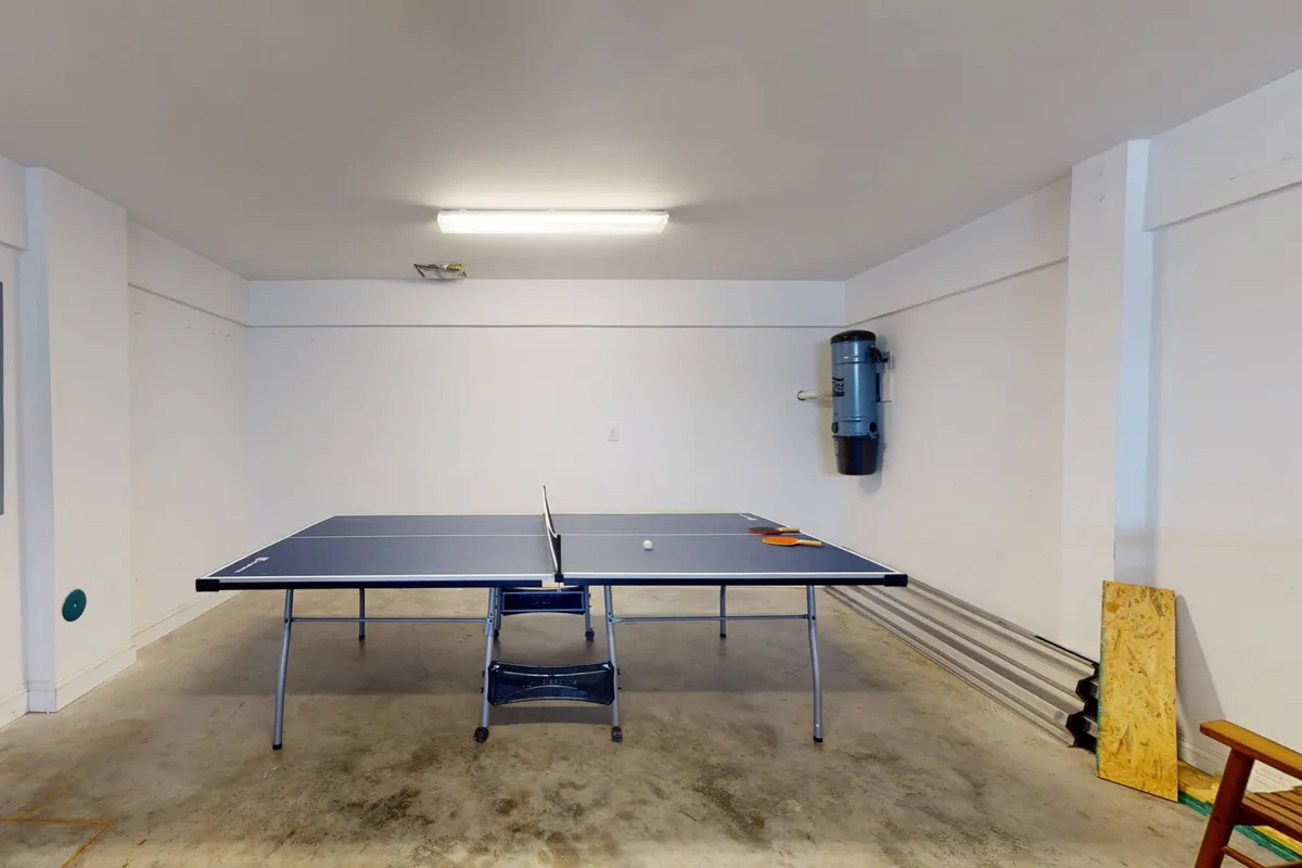 A fun and relaxed interior scene focused on a ping pong table, complete with paddles and balls, perfectly suited for friendly competitions and family fun.